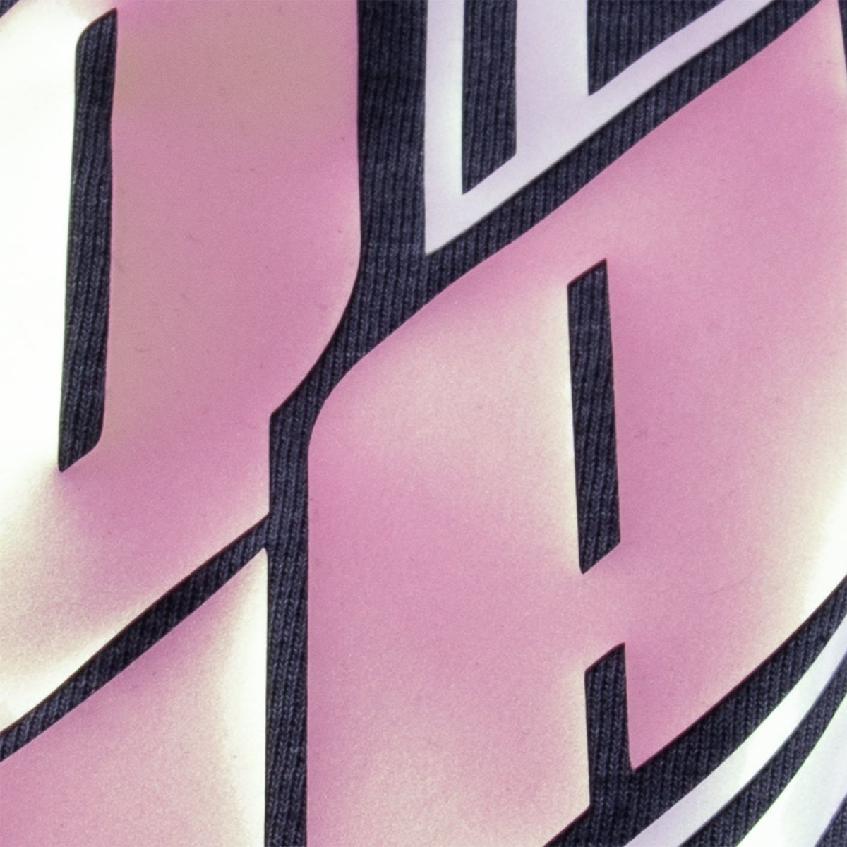 Close up of raised Brick 600 Pearl Pink lettering pressed on a garment