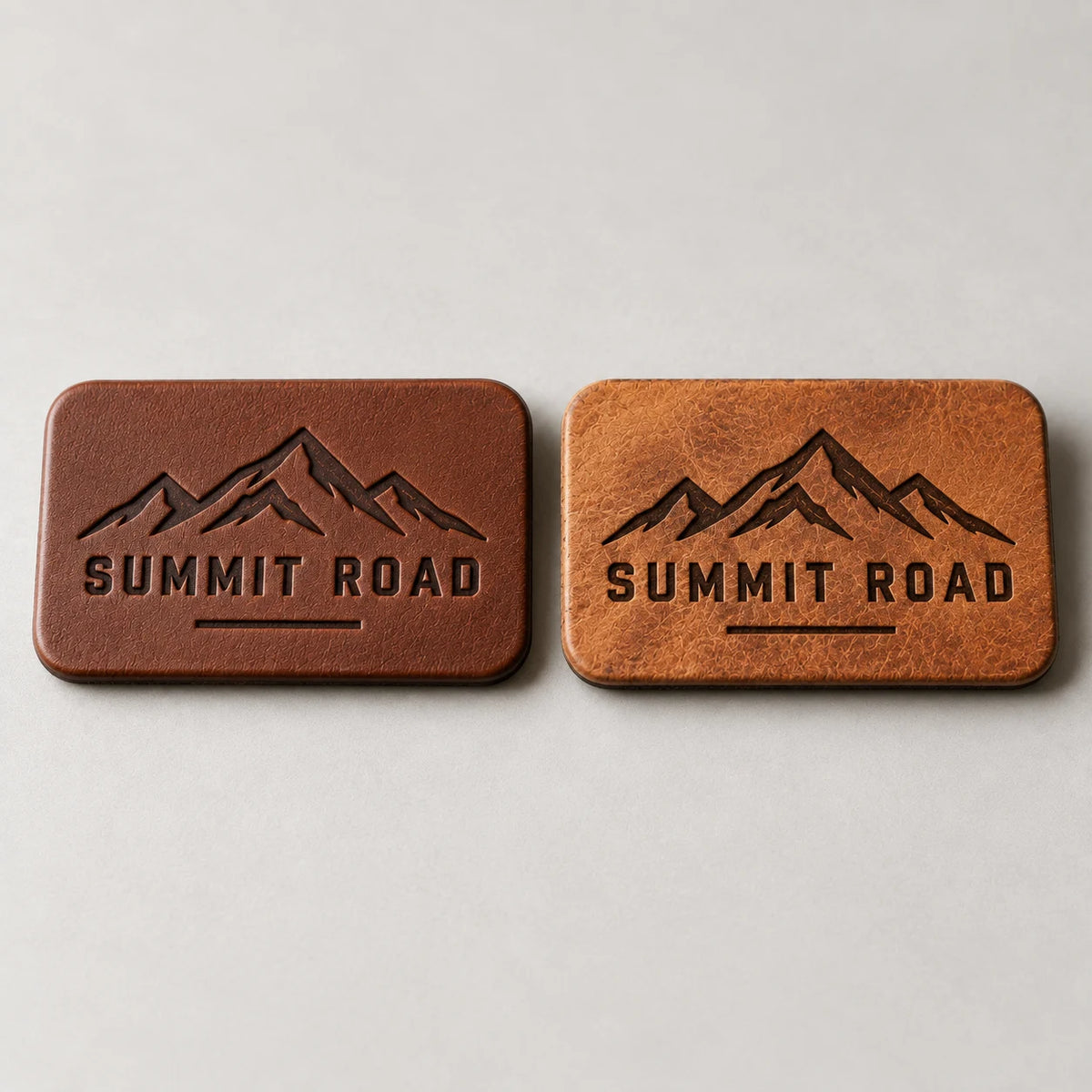 Faux leather debossed patch next to a genuine leather laser engraved patch